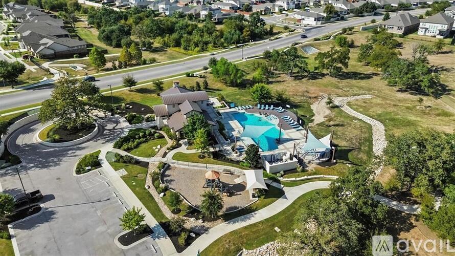 A bird's eye view of a residential area with a swimming pool and a playground.