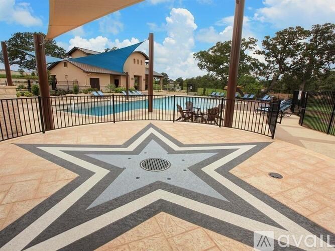 A pool area with a star patterned floor and a house in the background.