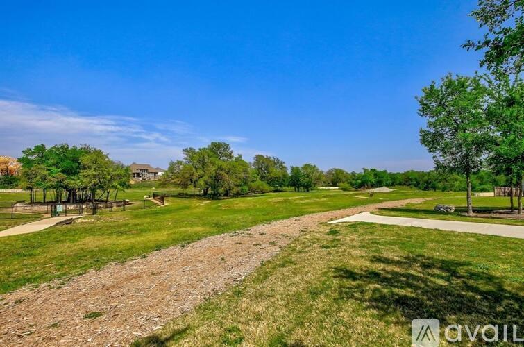 A park with a gravel path and grassy areas.