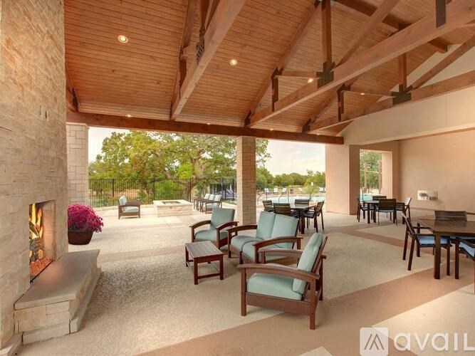 A patio with wooden furniture and a fireplace.