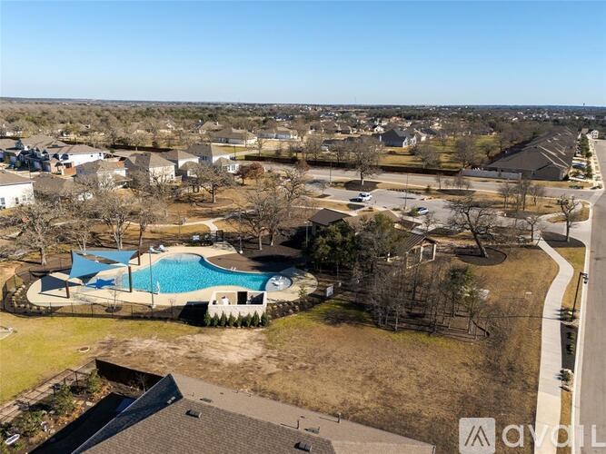 A bird's eye view of a residential area with a swimming pool.