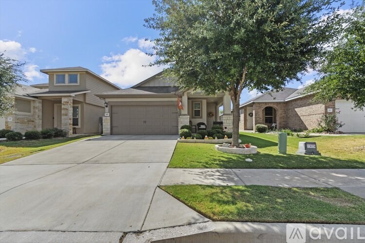 A house with a driveway and a tree in front.
