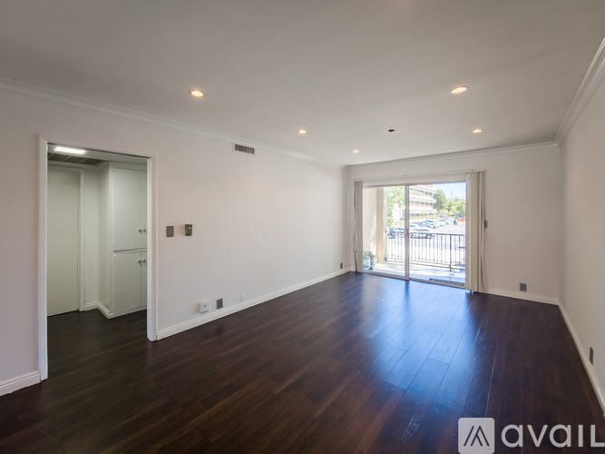 A spacious room with wooden floors and white walls.