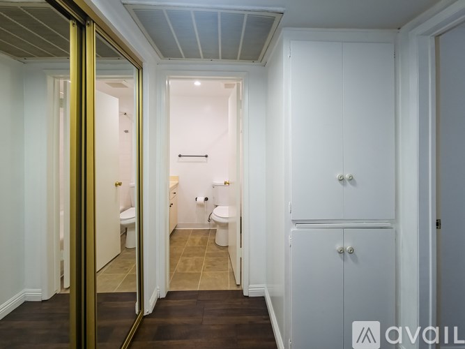 A bathroom with a toilet, sink, and a cabinet.