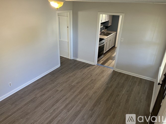 A room with a wooden floor and a white door.