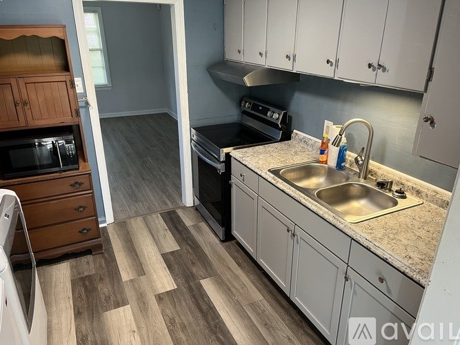 A kitchen with a sink, stove, and oven.