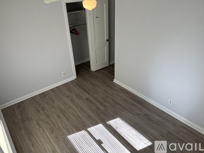 A room with a wooden floor and a white door.