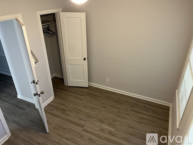 A room with a wooden floor and a white door.