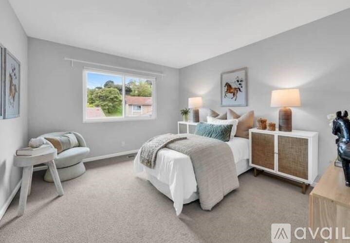 A bedroom with a large bed, a window with a view, and a wooden cabinet.
