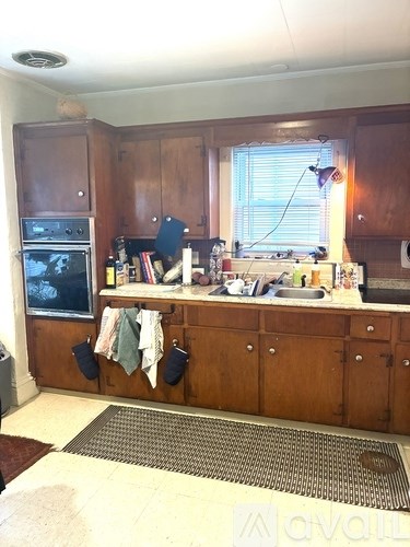 A kitchen with wooden cabinets and a window.