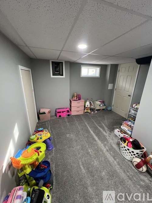 A room with a grey carpet and a white ceiling with a window.