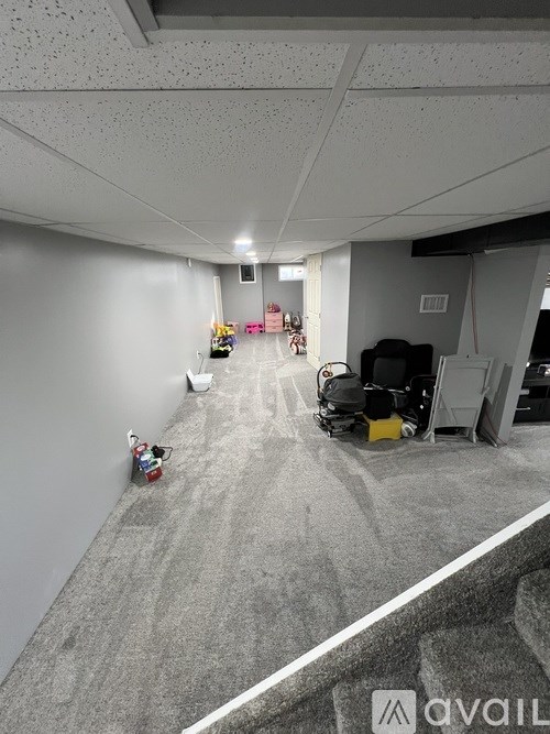 A room with a grey carpet and a white wall with a logo on it.