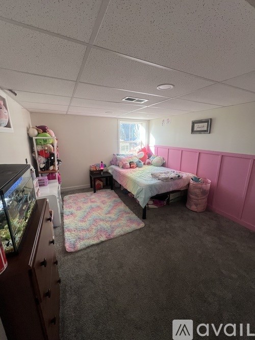 A room with a bed, a dresser, and a window.