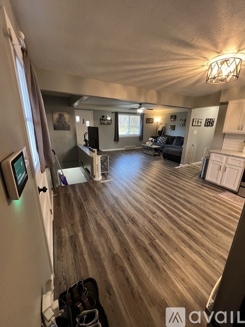 A living room with a couch, a television, and a guitar case on the floor.