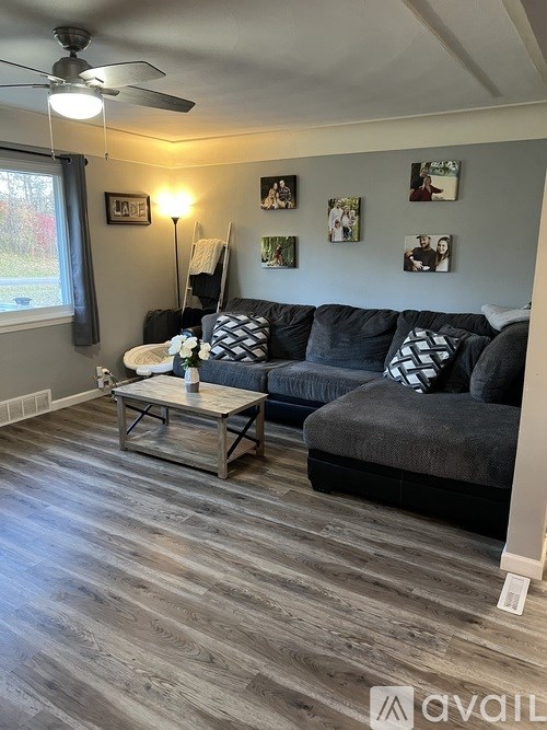 A living room with a grey couch and a wooden coffee table.