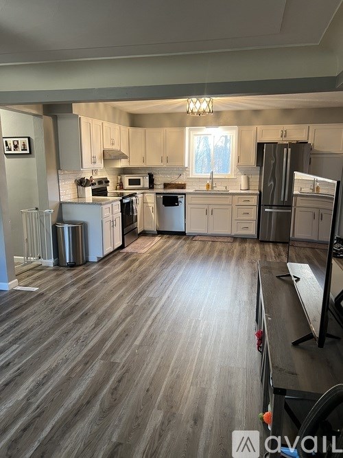 A kitchen with wood flooring and a variety of appliances.