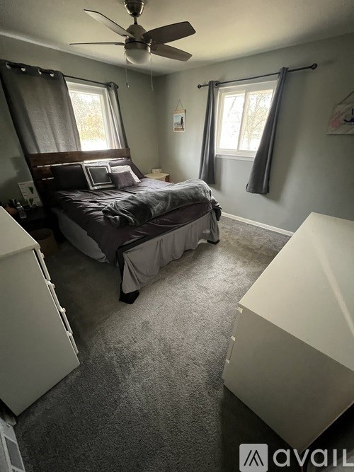 A bedroom with a bed, dresser, and window.