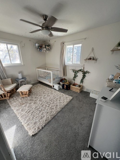 A baby room with a crib and a fan.