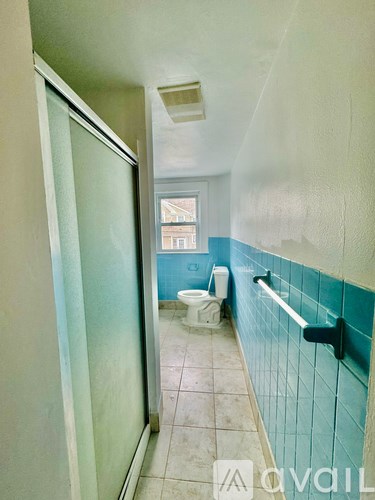 A bathroom with a toilet and a shower.