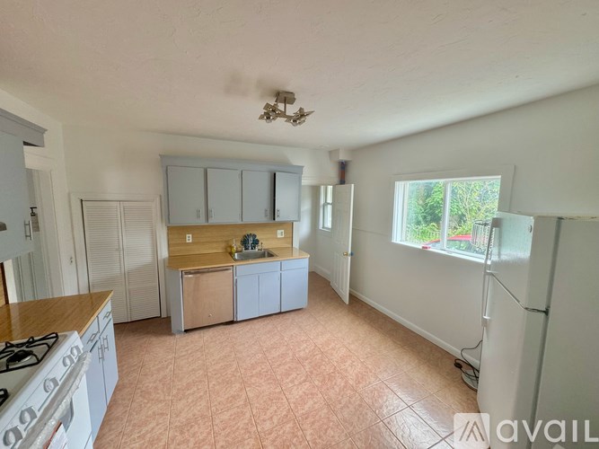 A kitchen with a stove top oven and a refrigerator.