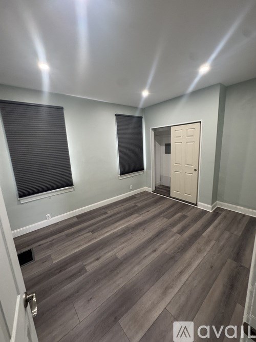 A room with wooden flooring and a white door.