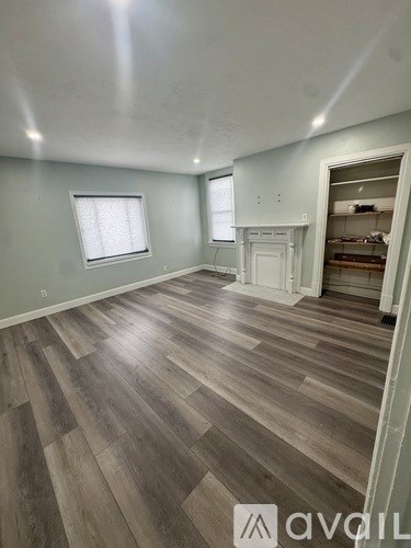A room with wooden flooring and a white door.