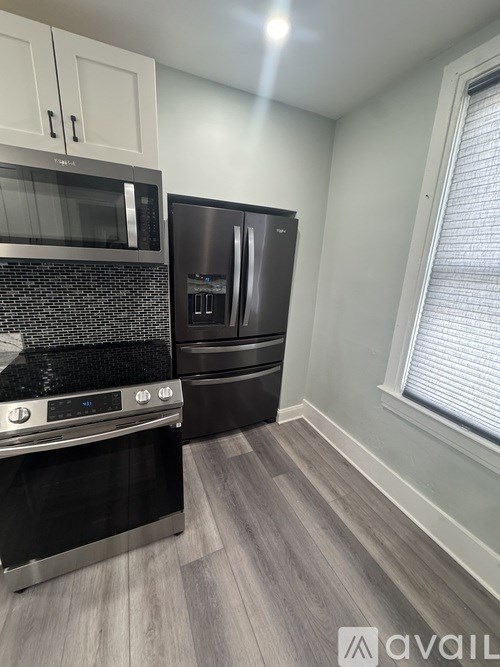 A kitchen with a black stove top oven and a black refrigerator.