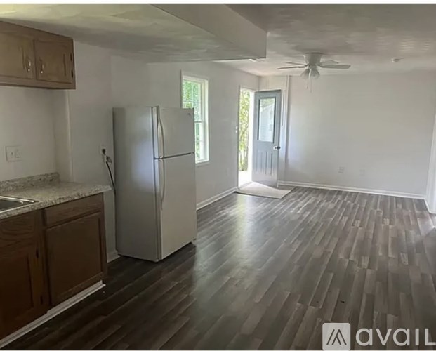 A kitchen with a refrigerator, cabinets, and a countertop.