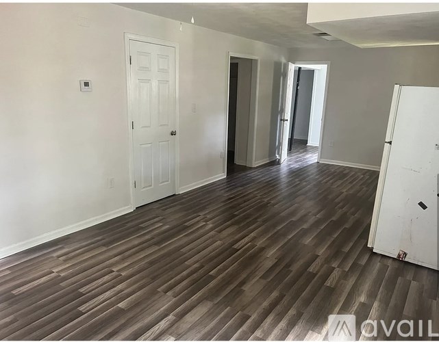 A room with wooden flooring and white walls.
