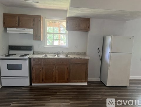 A kitchen with wooden cabinets and a white refrigerator.