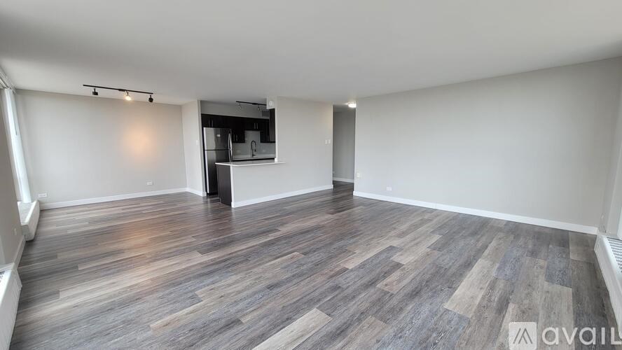 A spacious room with wooden flooring and a television in the corner.