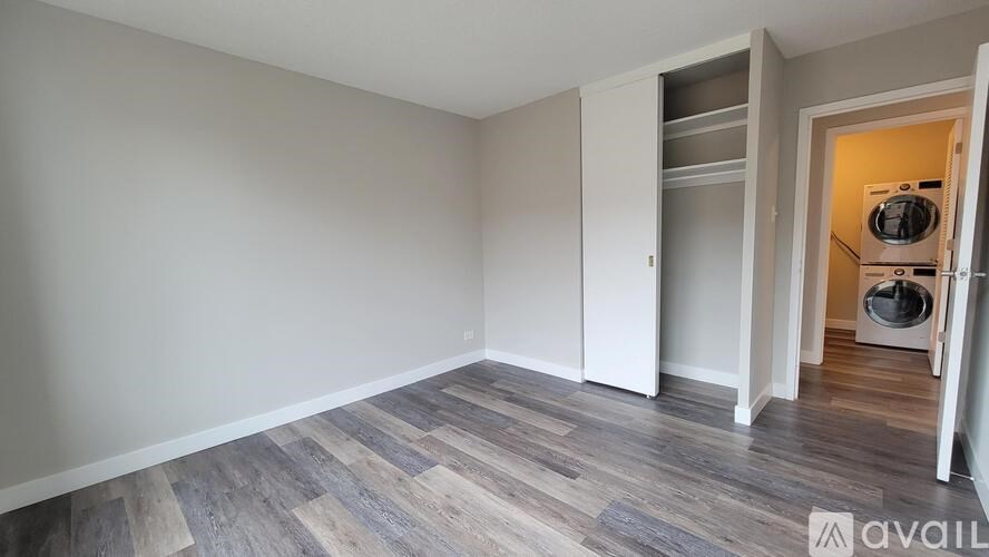 A room with a wooden floor and a white wall.