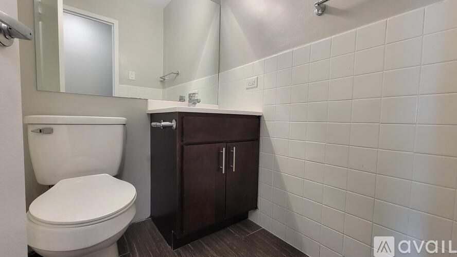A white toilet sits next to a white sink in a small bathroom.