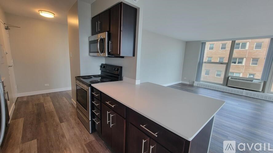 A kitchen with dark wood cabinets and a white countertop.