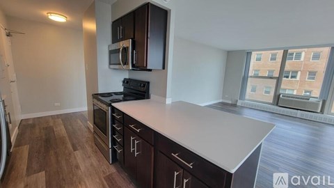 A kitchen with dark wood cabinets and a white countertop.