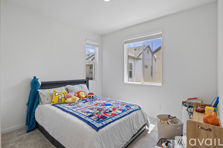 A bedroom with a bed, a window, and a wall hanging.
