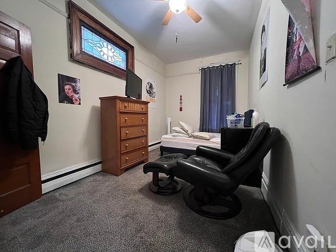 A room with a black chair and a wooden cabinet.