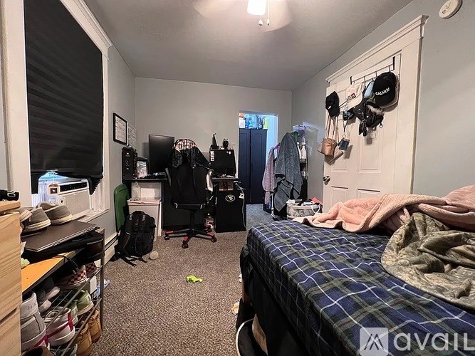 A bedroom with a bed, desk, chair, and closet.