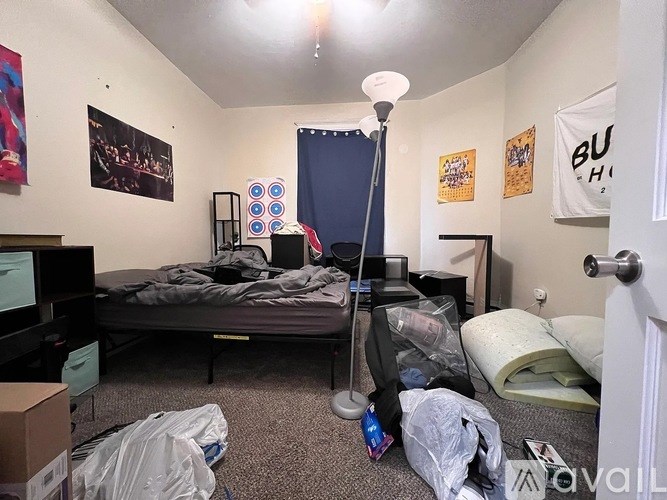 A bedroom with a bed, a desk, and a computer.