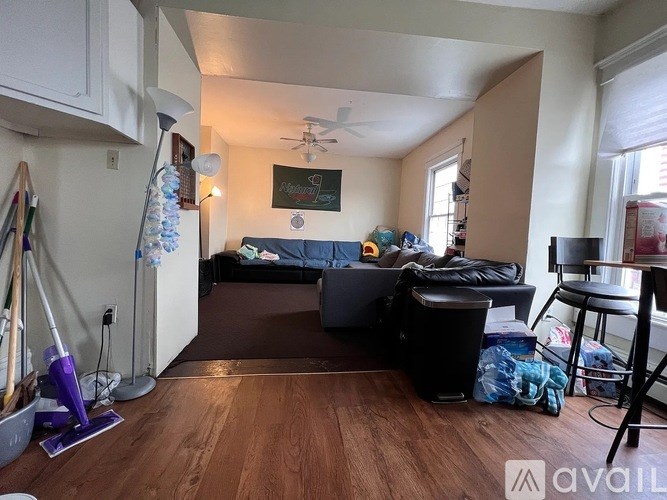 A living room with a couch, a chair, and a vacuum cleaner.