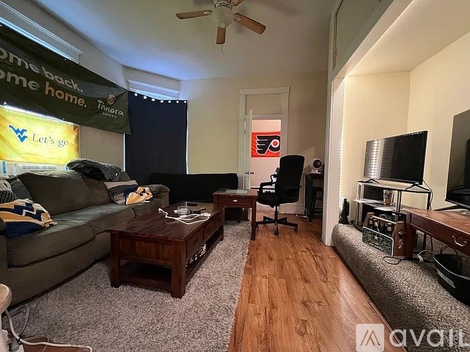 A living room with a couch, chair, and television.