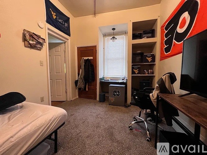 A bedroom with a bed, desk, and a hockey logo on the wall.