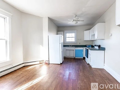A kitchen with white cabinets and a wooden floor.
