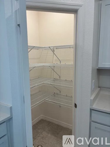 A white pantry with a white door and a white cabinet.