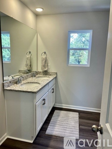 A bathroom with a marble countertop and a window.