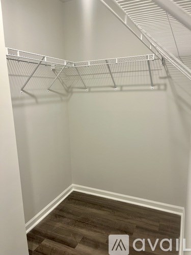 A white wall with a metal shelf on it.
