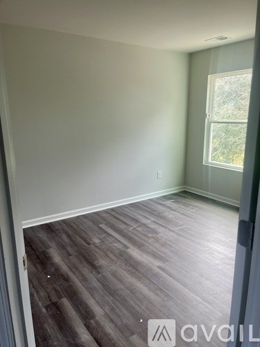A room with wooden flooring and a window.