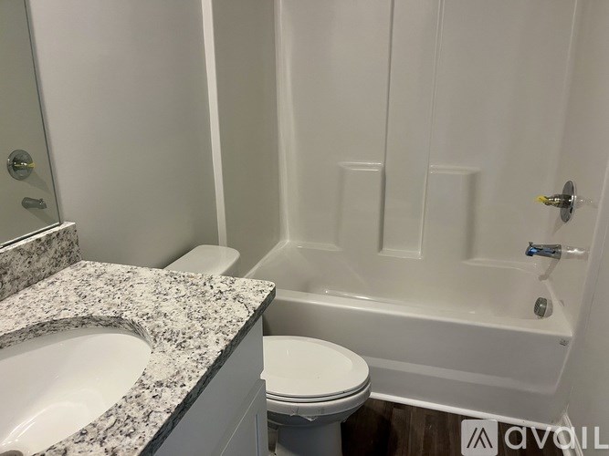 A white bathroom with a sink, toilet and bathtub.