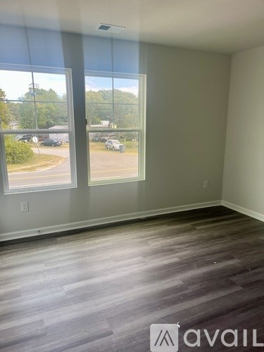 A room with a large window overlooking a parking lot.