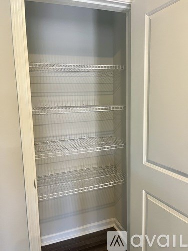 Empty glass shelves in a white cabinet.